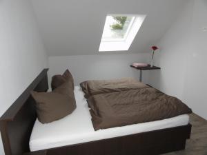 ein kleines Schlafzimmer mit einem Bett und einem Fenster in der Unterkunft Spreewaldapartments in Lübben