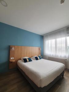 Un dormitorio con una cama grande con paredes azules. en Hôtel Le Rivage vue sur mer - Châtelaillon-plage, en Châtelaillon-Plage