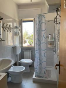 y baño con aseo, lavabo y ducha. en Apartments happy family 1 en Ginosa Marina