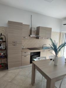 a kitchen with wooden cabinets and a table with a plant at Lovin Puglia Vacation in Bari