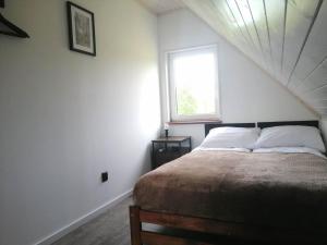 Schlafzimmer mit einem Bett und einem Fenster in der Unterkunft Domek całoroczny na mazurach in Orzysz