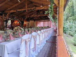 une rangée de tables avec des nappes blanches et des archets roses dans l'établissement Park Hédervár, à Hédervár