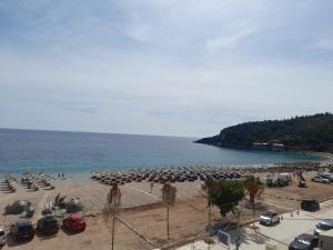 a beach with a bunch of umbrellas and cars on it at Anxhelos Hotel in Himare