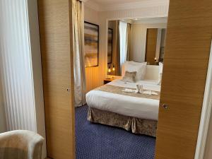 Pokój hotelowy z łóżkiem i lustrem w obiekcie Maison LUTETIA R w Strasburgu