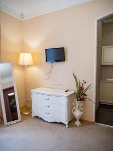 a room with a white dresser and a tv on the wall at Hotel Madrid in Odesa