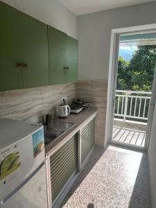 a kitchen with green cabinets and a counter top at Prado Hotel Apartments in Limín Litochórou