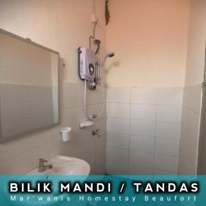 ein Bad mit einer Dusche, einem Waschbecken und einem Spiegel in der Unterkunft Mar'Wanis Homestay Beaufort Sabah in Beaufort