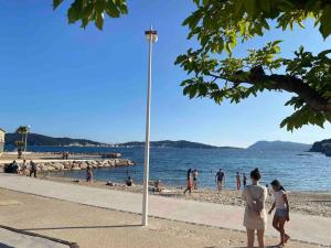 a group of people on a beach near the water at cosy appartement avec parking au centre et port in Toulon