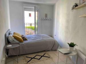 a bedroom with a bed and two tables and a window at cosy appartement avec parking au centre et port in Toulon