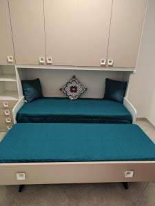 a bedroom with two beds with blue sheets at Lovin Puglia Vacation in Bari