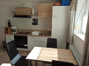eine Küche mit einem Tisch und einem weißen Kühlschrank in der Unterkunft Haus Ferdinand in Leutasch