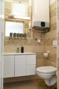 a bathroom with a toilet and a sink and a window at VillaBeach 50m from the beach in Fonyód