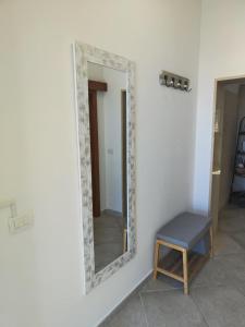 a mirror on a wall with a bench in a room at Lovin Puglia Vacation in Bari