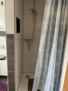 La salle de bains est pourvue d'une douche avec rideau de douche. dans l'établissement Ferienwohnung Heidi, à Wahlhausen