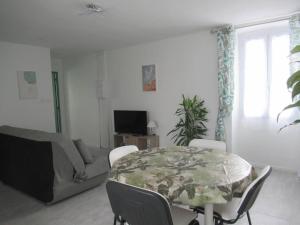 - un salon avec une table et un canapé dans l'établissement Gîte la Chaumette appartement Emeraude, à Villeuneuve-de-Berg