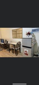 a kitchen with a table and a table and a stove at Khentdrick's Place at Holland Park Southwoods in Biñan