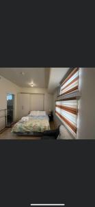 ein kleines Schlafzimmer mit einem Bett und einem Fenster in der Unterkunft Khentdrick's Place at Holland Park Southwoods in Biñan