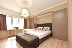 a bedroom with a large bed and a large window at Knokke Top Bel Mooi appartement 8P Le Caducée in Knokke-Heist