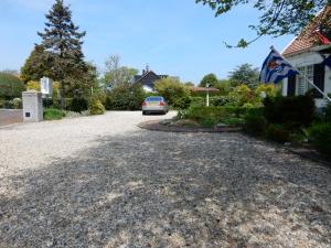 a driveway with a car parked in front of a house at De Waterlelie in Renesse