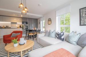 un soggiorno con divano bianco e tavolo di The Winnoch - modern 2 bed flat a Lochwinnoch