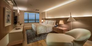 a hotel room with a bed and a chair at Hotel Gran Marquise in Fortaleza