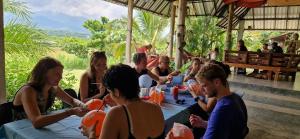 eine Gruppe von Menschen, die um einen Tisch herum sitzen in der Unterkunft Atlas Valley in Pai