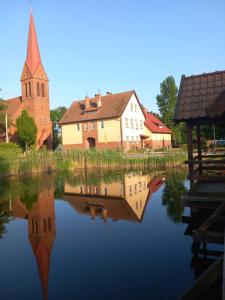 a reflection of a church in a body of water at Kwatery pod wieżą 