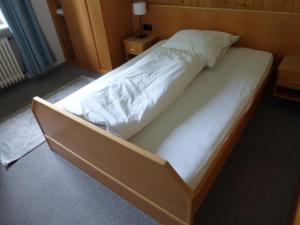 ein großes Bett in einem Zimmer mit weißer Bettwäsche in der Unterkunft Gasthaus Zum goldenen Löwen in Finkenbach