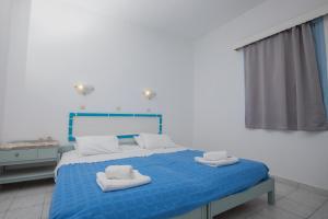 帕特莫斯的住宿－Pico Bello Patmos 28，一间卧室配有蓝色的床和毛巾