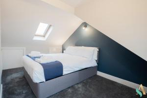Un dormitorio con una cama con una pared de acento azul en Trent House TSAC, en Stockton-on-Tees