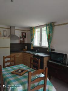 a kitchen with a table and a kitchen with a table and chairs at Les cyprès in Lagorce