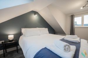 um quarto com uma cama grande e lençóis brancos em Trent House TSAC em Stockton-on-Tees