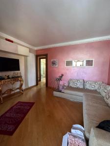 een woonkamer met een bank en een roze muur bij Peaceful and near town in Terranuova Bracciolini