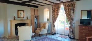 un salon avec une cheminée, une chaise et une fenêtre dans l'établissement Manoir Petit Meysset, à Sarlat-la-Canéda