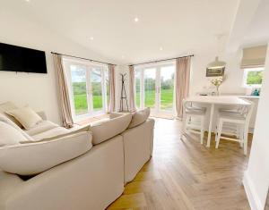 a living room with a white couch and a table at Orchard Cottage - Kent in Lyminge