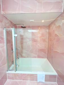 a bathroom with a shower with a glass door at Orchard Cottage - Kent in Lyminge +25 photos