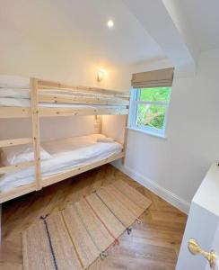 a room with two bunk beds and a window at Orchard Cottage - Kent in Lyminge