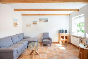uma sala de estar com um sofá e uma mesa em Haus zu den Halligen em Bredstedt