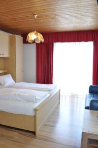 a bedroom with a bed and a red curtain at Gästehaus Herlinde in Podersdorf am See