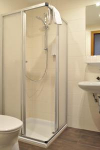 y baño con ducha y puerta de cristal. en Gästehaus Herlinde, en Podersdorf am See