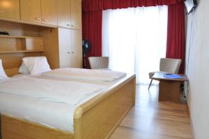 een slaapkamer met een bed in een kamer met een raam bij Gästehaus Herlinde in Podersdorf am See