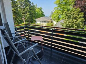 a balcony with two chairs and a fence at Seeblick Kampf mit Fahrradgarage in Nonnenhorn