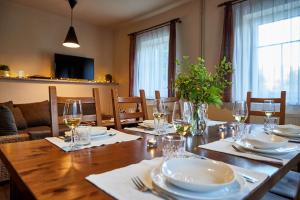 - une salle à manger avec une table en bois, des assiettes et des verres à vin dans l'établissement Chata Slunce, à Malá Morávka