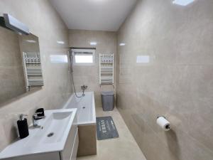 a white bathroom with a sink and a mirror at DeLux Apartments with Terassa in Towers Ever Green in Iaşi