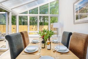 a dining room with a table with chairs and a window at 1 Afon y Felin in Abersoch