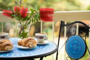 a table with two cups of coffee and croissants at Ammare Bed & Breakfast in Marina di Camerota