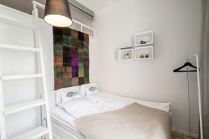 a small bedroom with a bed and a lamp at Luxury Design Gem in City Center with Sauna and workspace in Helsinki