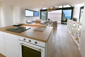 a kitchen with white cabinets and a counter top at Ty Dag - Petite Terre vue mer, spa, plage à 300m in Roscoff