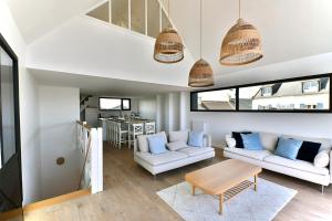 een woonkamer met twee witte banken en een tafel bij Ty Dag - Petite Terre vue mer, spa, plage à 300m in Roscoff