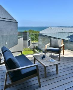 patio z 2 krzesłami i stolikiem kawowym na tarasie w obiekcie Ty Dag - Petite Terre vue mer, spa, plage à 300m w mieście Roscoff